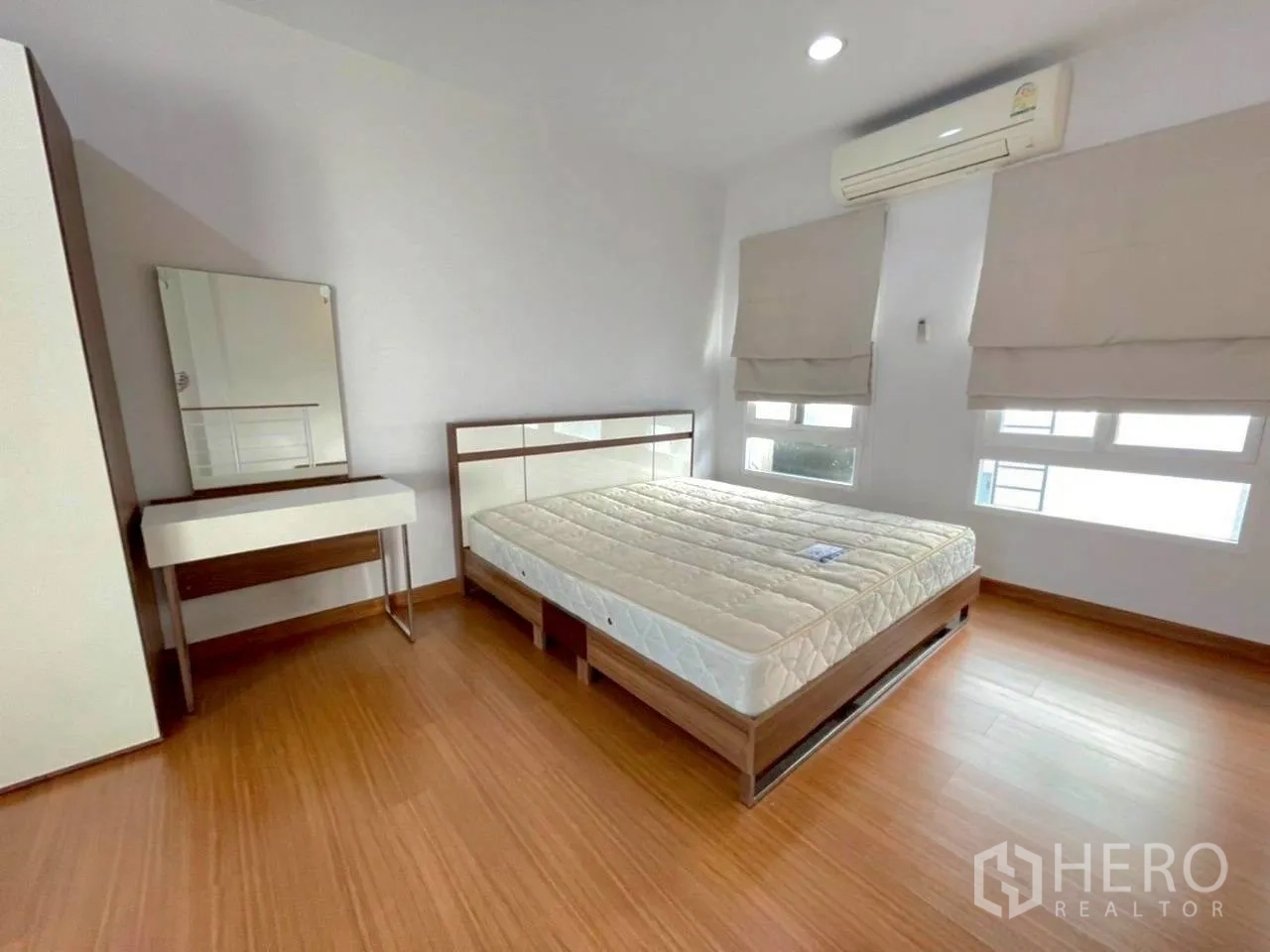 Townhouse for rent in Bang Kho Laem, Bangkok - Spacious bedroom with double bed, vanity, wardrobe, wood floors and air conditioning.