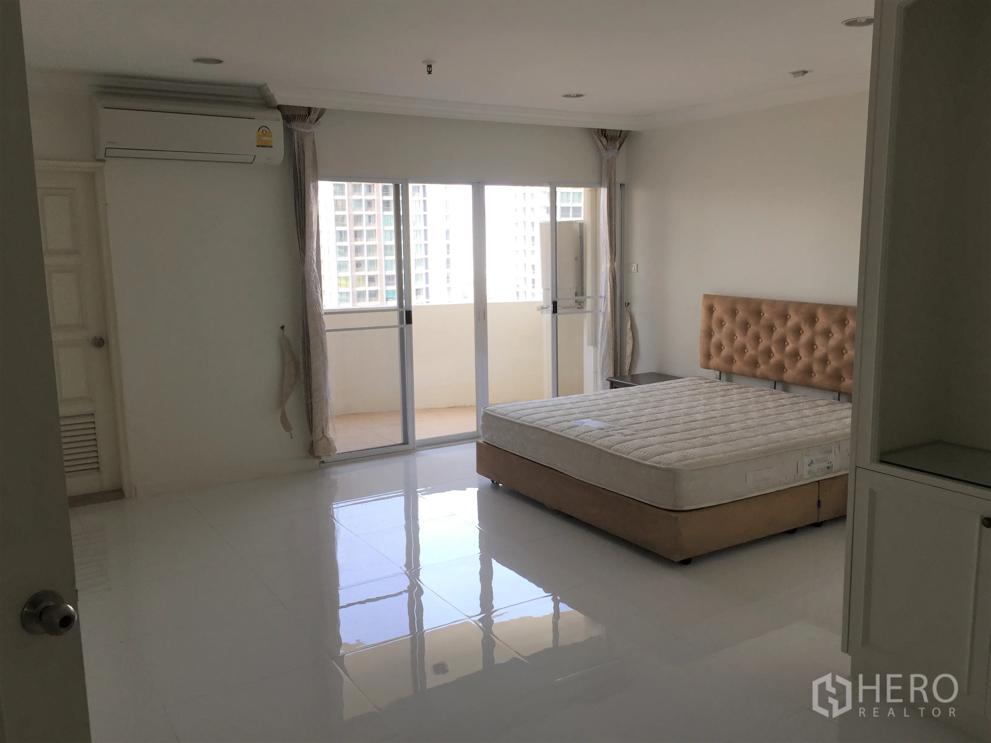 公寓 出租在Watthana, Bangkok - 主卧连接阳台，享城市景观与亮面地砖。