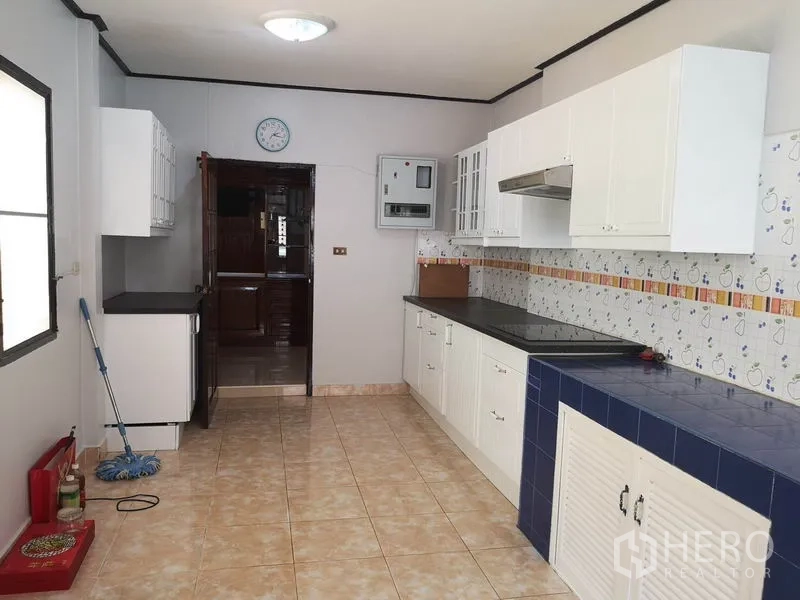 Detached House for sale - Long galley kitchen with white cabinetry, tiled backsplash and ample counter space.