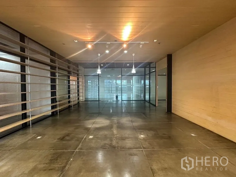 Office Space for rent in Khlong Toei, Bangkok - Reception or showroom area with pendant lights, polished concrete floor, and glass partitions.