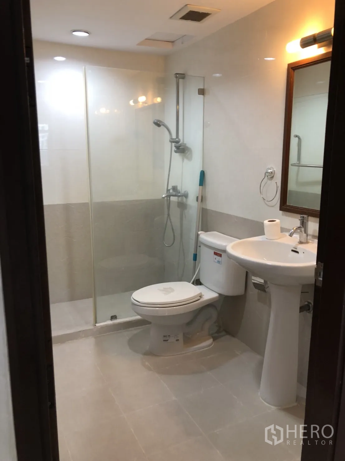 Condominium for rent in Watthana, Bangkok - Renovated bathroom with glass shower, pedestal sink and WC.