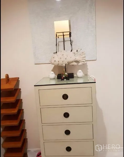 Condominium for rent in Sathon, Bangkok - White chest of drawers with a mirror and ornaments in a cozy corner.