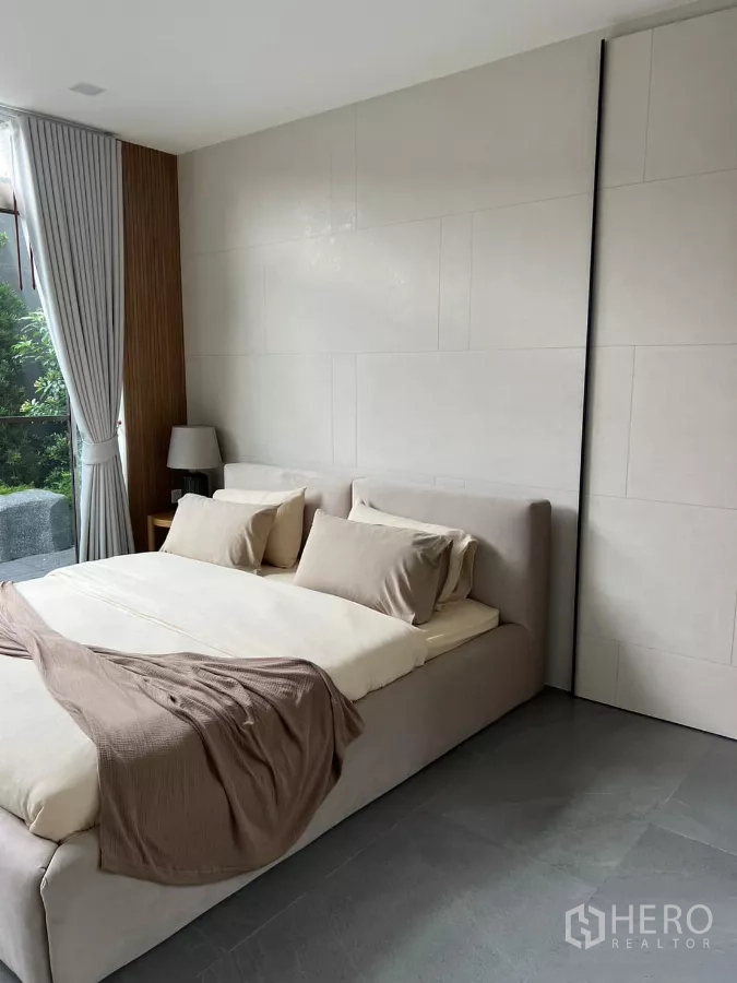 Detached House for rent in Saphan Sung, Bangkok - Cozy bedroom with neutral linens, low headboard and a garden outlook.