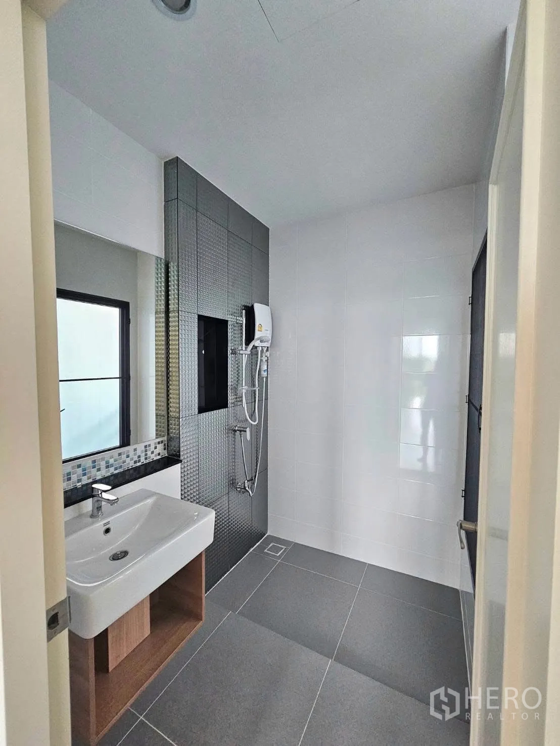 Townhouse for rent in Saphan Sung, Bangkok - Bathroom with walk-in shower, mosaic accent tiles, vanity sink, and water heater.