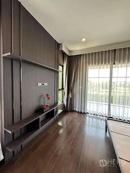 独立式住宅 出售在Prawet, Bangkok - 卧室，深木色电视墙与落地窗。