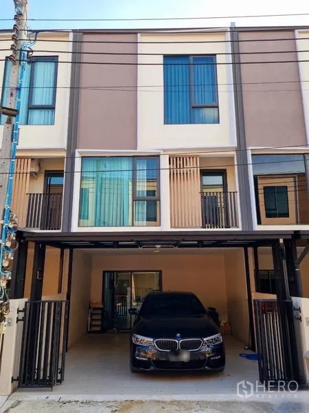 Townhouse for rent - Modern three-storey townhouse facade with a gated covered carport.