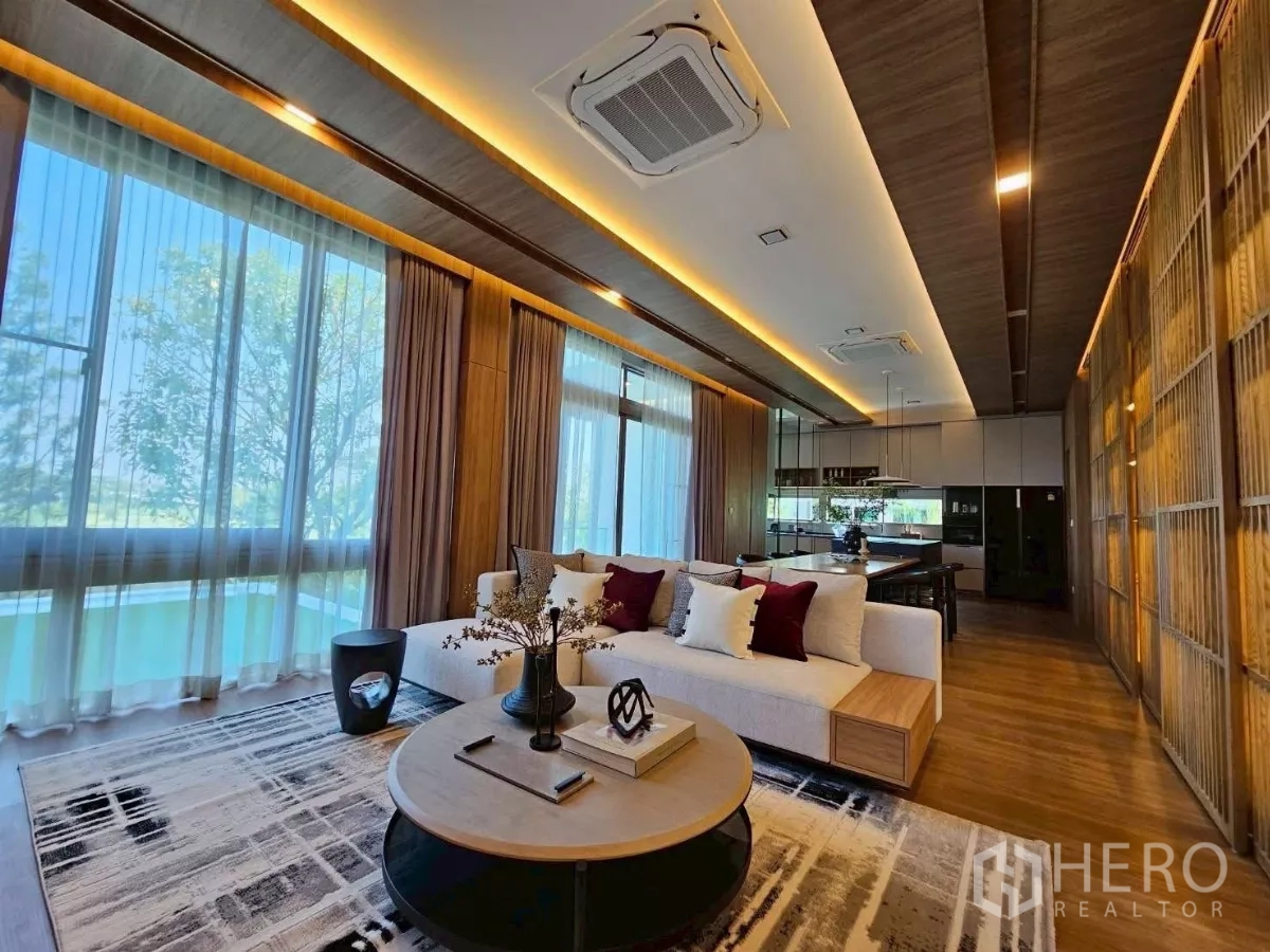 Detached House for rent in Saphan Sung, Bangkok - Bright lounge with floor-to-ceiling windows, sectional sofa, and dining area.