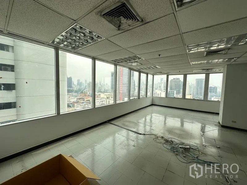 办公空间 出租在Chatuchak, Bangkok - 明亮的转角工作区，吊顶送风口与大窗俯瞰市中心