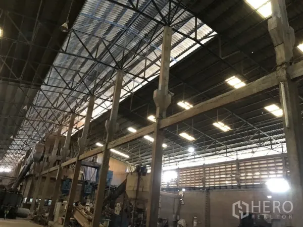 Factory for rent in Bang Bua Thong, Nonthaburi - Close view of steel truss roof and columns with skylights across the factory ceiling.