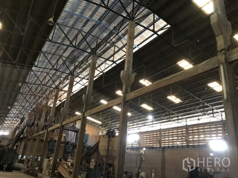 Factory for rent in Bang Bua Thong, Nonthaburi - Close view of steel truss roof and columns with skylights across the factory ceiling.