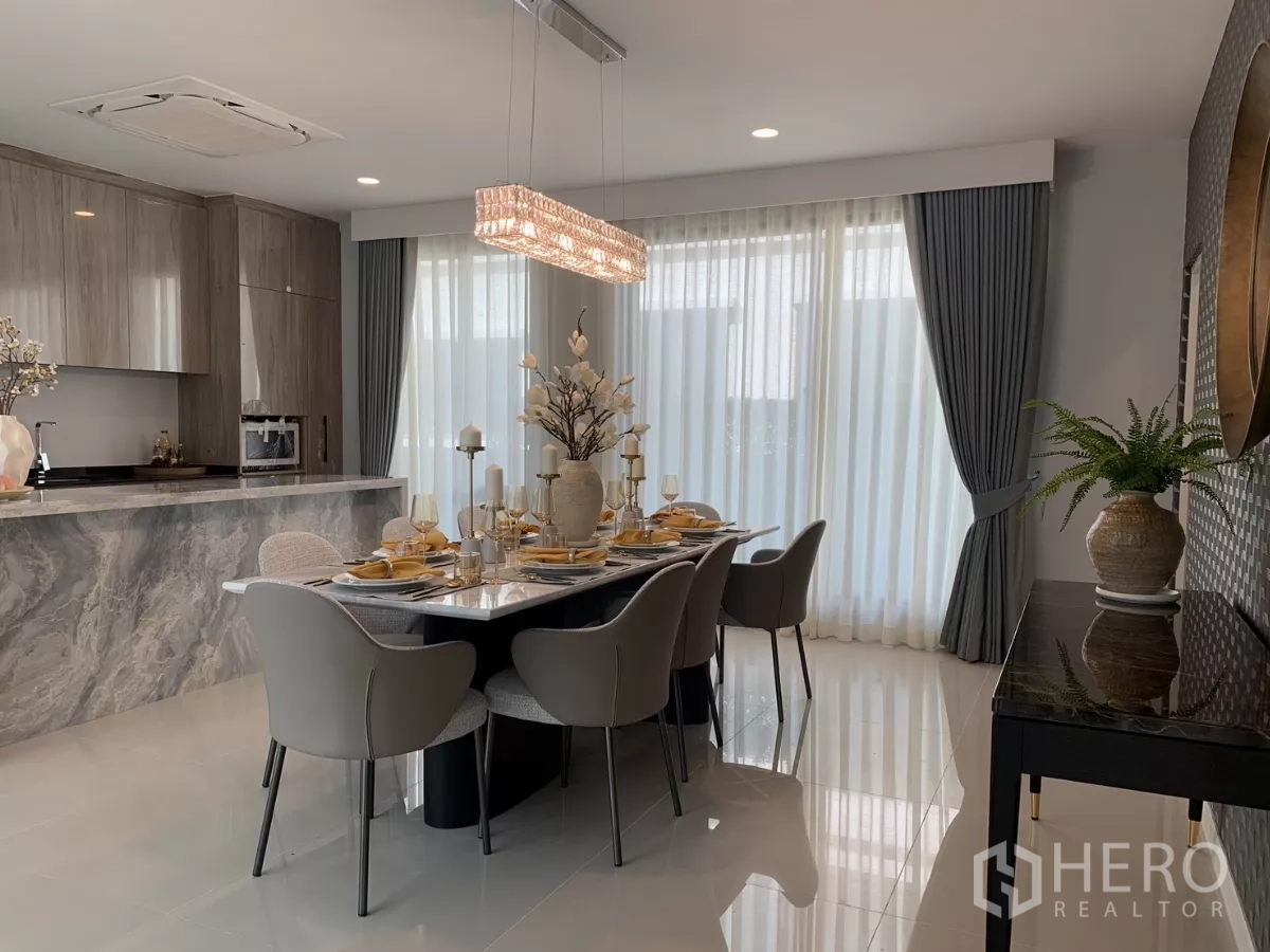 Detached House for rent in Bang Kapi, Bangkok - Open dining and kitchen with marble island, six‑seat table and crystal pendant lighting.