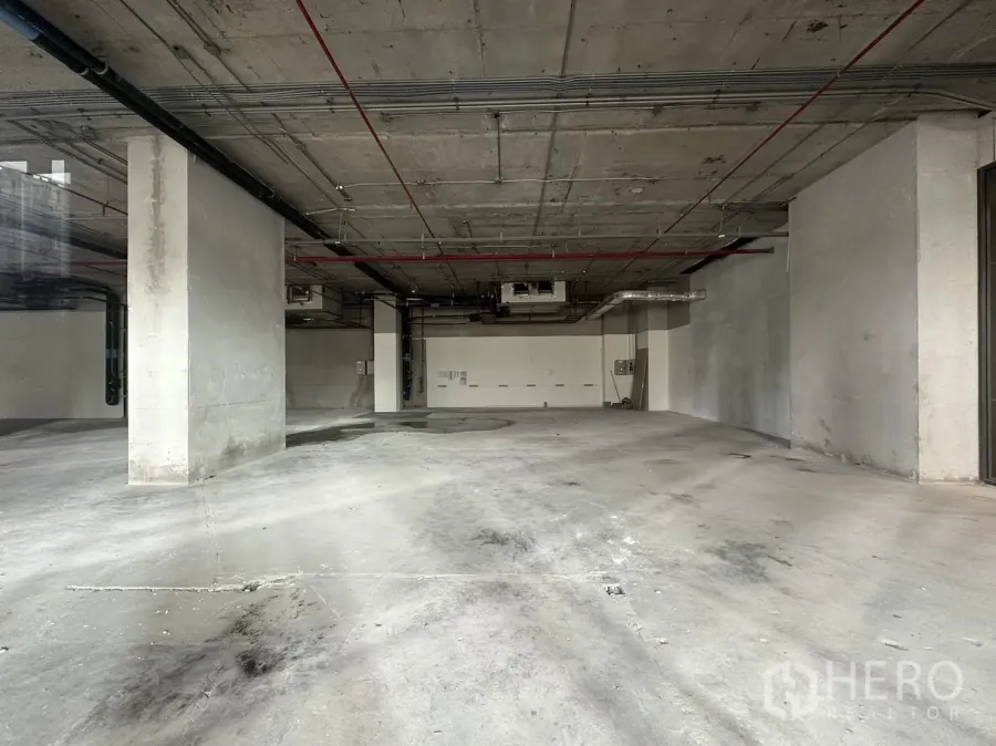 Retail Space for rent - Bare-shell retail interior with exposed concrete ceiling, columns, ducts, and an open plan ready for fit-out.