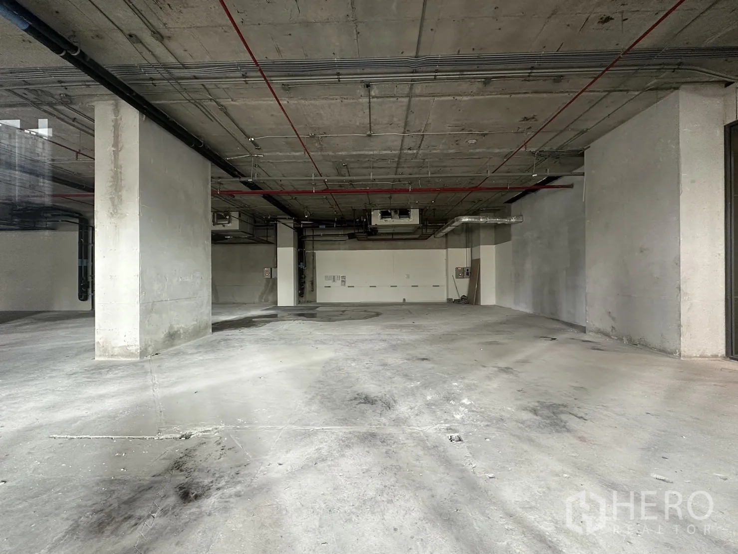 Retail Space for rent - Bare-shell retail interior with exposed concrete ceiling, columns, ducts, and an open plan ready for fit-out.