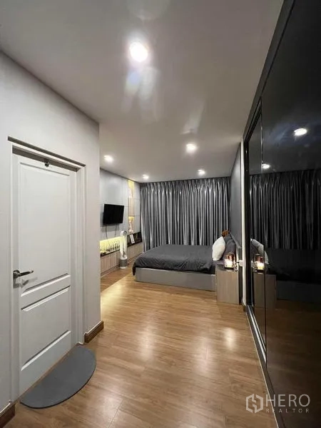 独立式住宅 出租或出售在Lat Krabang, Bangkok - 主卧视角，灰色窗帘、床与镜面衣柜。