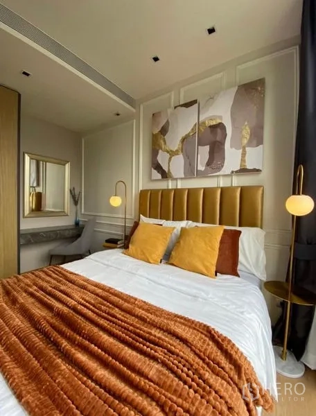 Condominium for rent - Bedroom with gold upholstered bed, rust throw, built‑in desk and wardrobe.