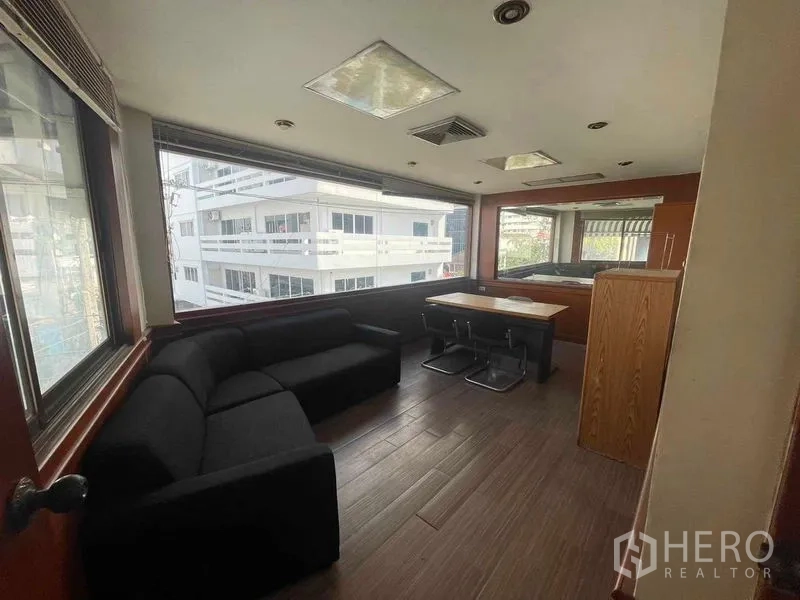 店屋 出租在Phaya Thai, Bangkok - 转角行政办公室，设沙发、书桌与宽幅景观窗。