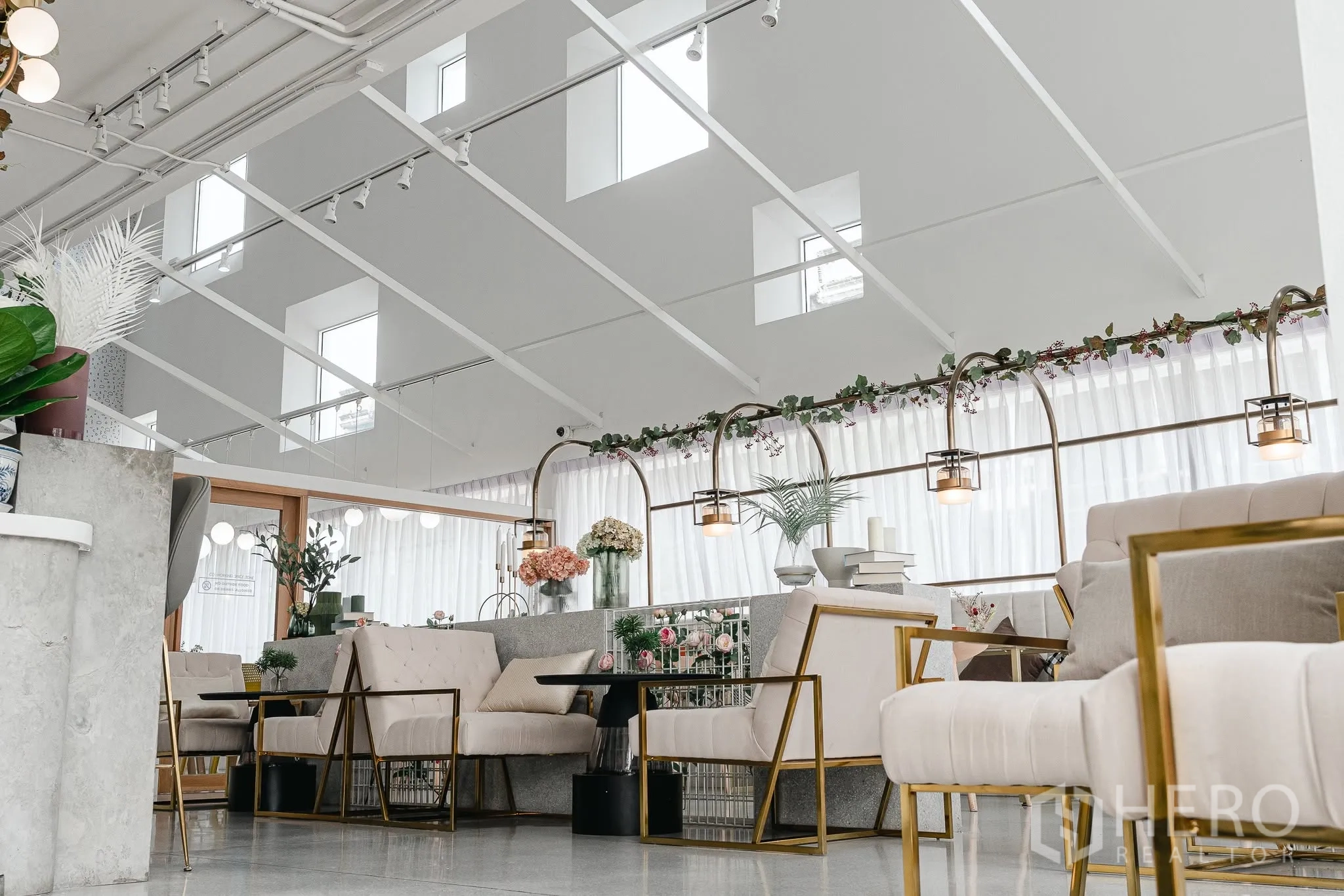 Office Space for rent in Bang Kapi, Bangkok - Bright lounge area with high ceilings, gold-framed armchairs, and decorative lighting.