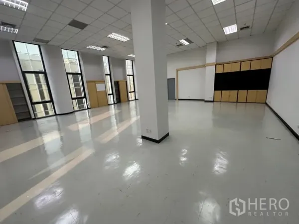办公空间 出租 - 宽阔的开放式办公区，亮面地板、格栅吊顶与立柱，竖窗引入充足自然光。