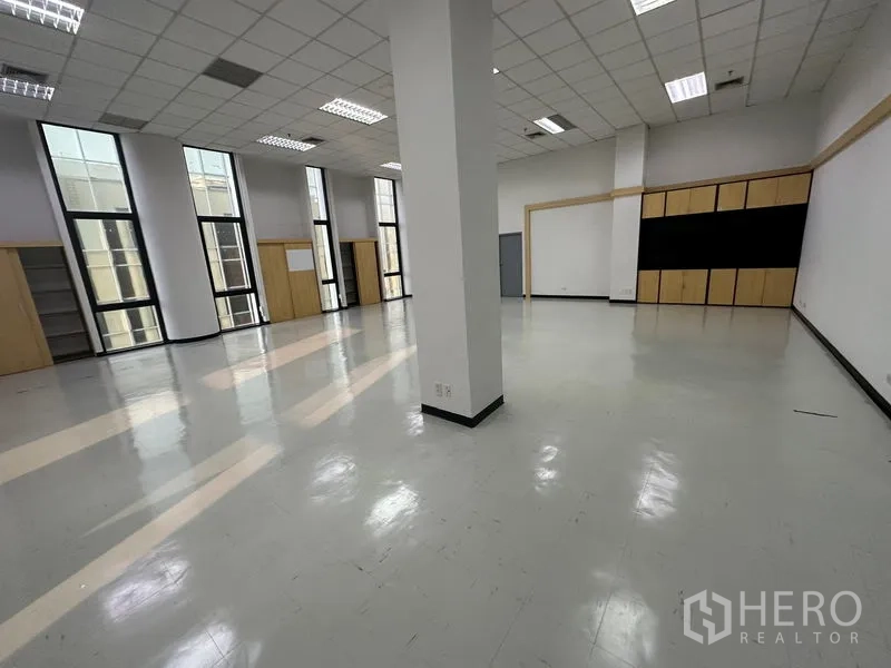 办公空间 出租 - 宽阔的开放式办公区，亮面地板、格栅吊顶与立柱，竖窗引入充足自然光。