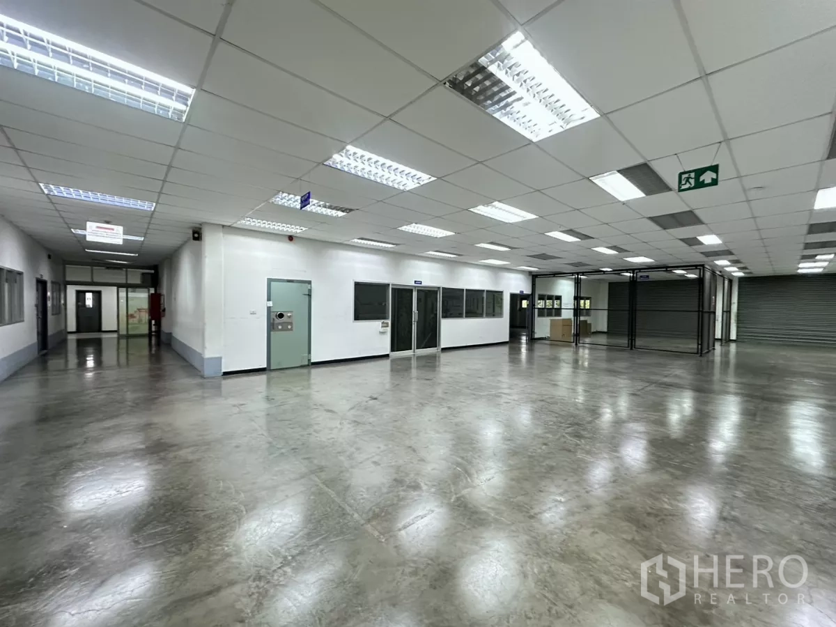 工厂 出售在Lat Krabang, Bangkok - 工作大厅，带玻璃办公室、安全标识与卷闸门。