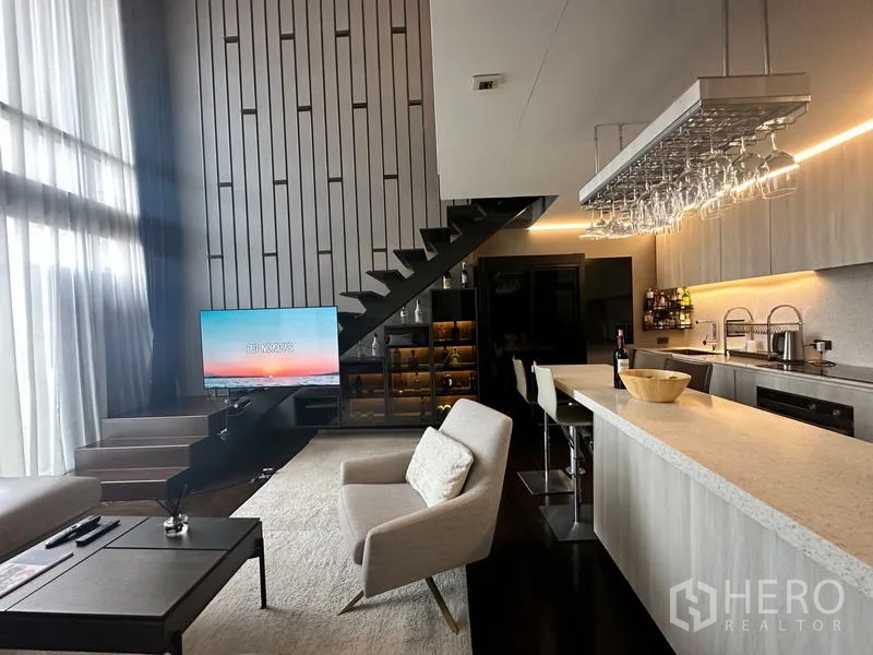 公寓 出售在Watthana, Bangkok - 起居区配电视、悬空楼梯与酒柜，毗邻岛台厨房