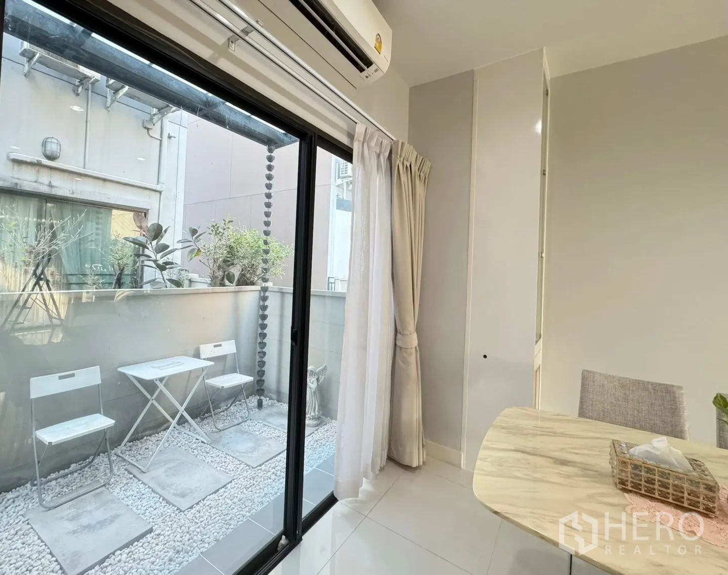 Townhouse for rent in Saphan Sung, Bangkok - Dining area opening to a private pebble patio with small bistro set via sliding doors.