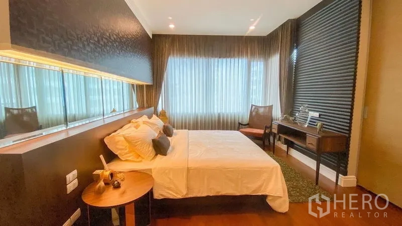 Condominium for rent in Khlong Toei, Bangkok - Second bedroom with a large window, work desk and ambient lighting.