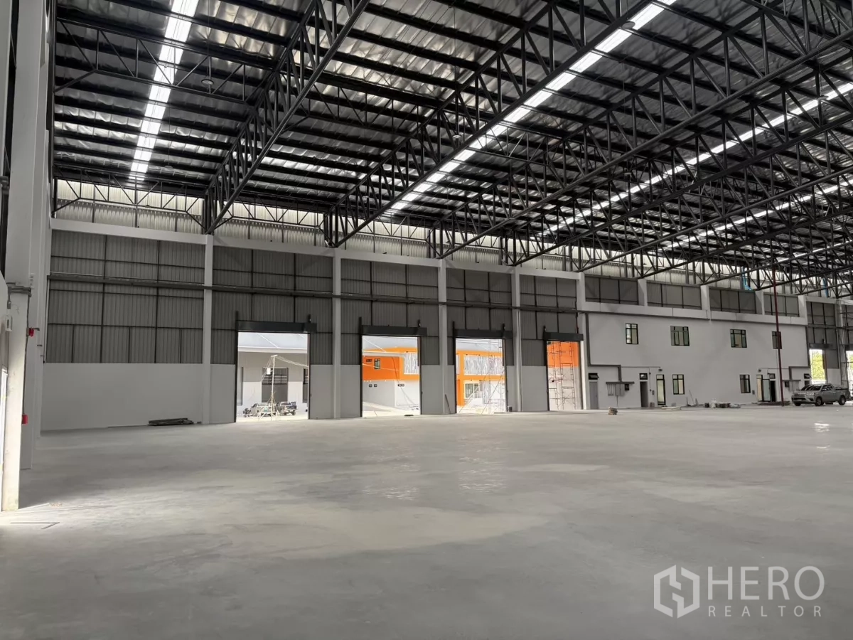 Factory for rent in Bang Pakong, Chachoengsao - Production area facing multiple loading doors and windows beneath the high roof.