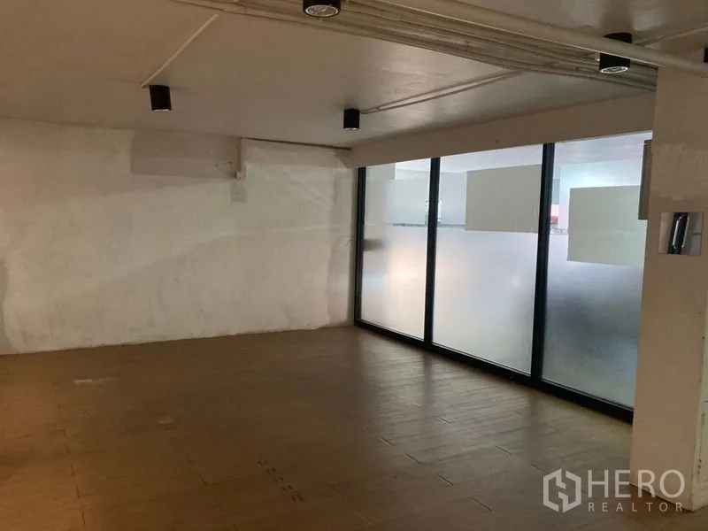 Retail Space for rent in Khlong Toei, Bangkok - Quiet rear section with textured white wall and frosted windows admitting diffused light.