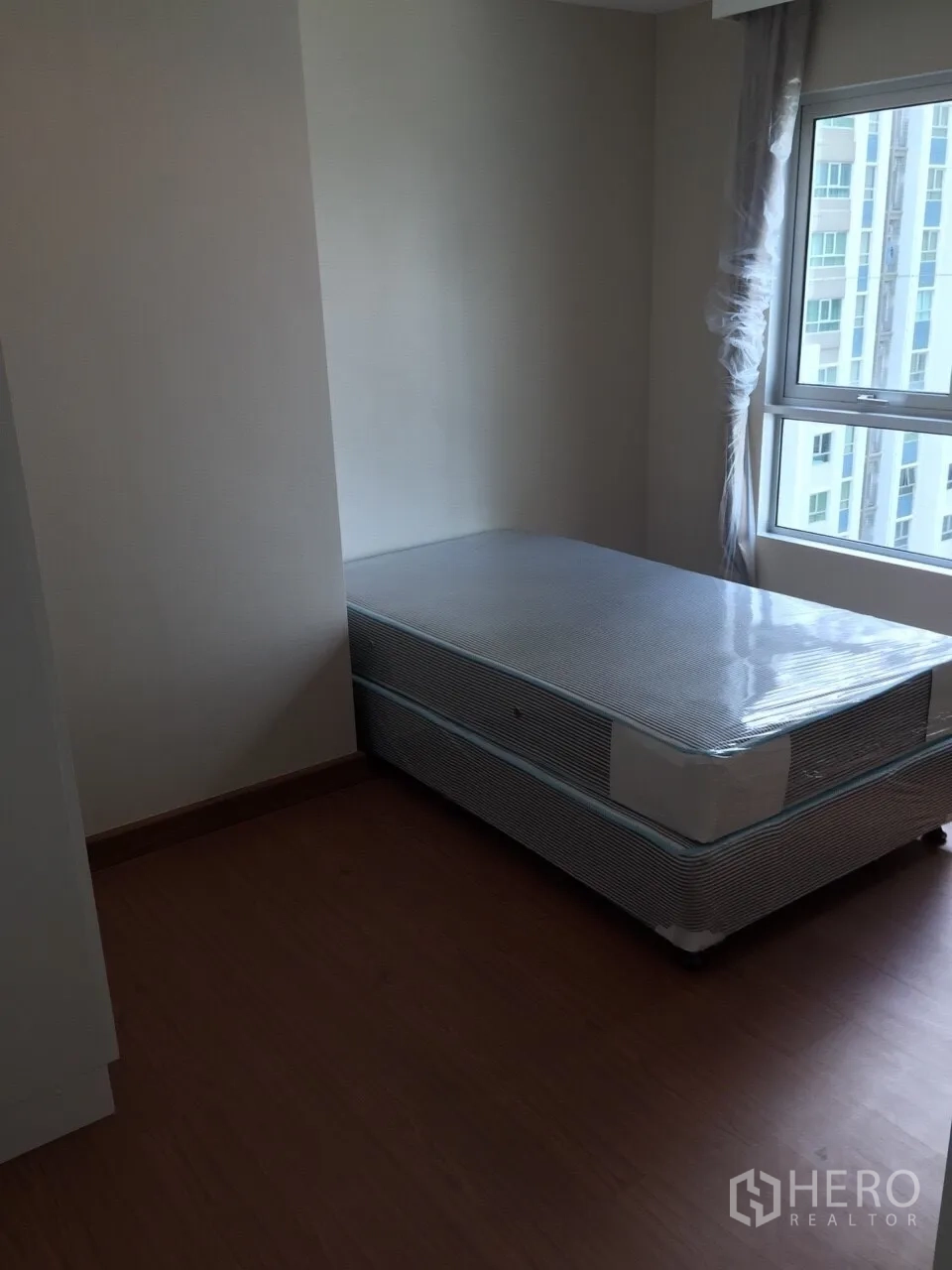 คอนโด ให้เช่าในHuai Khwang, Bangkok - ห้องนอนสว่าง เตียงเดี่ยวติดหน้าต่าง มองเห็นวิวเมืองย่านพระราม 9.
