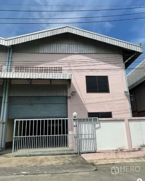 Warehouse for rent in Bang Bua Thong, Nonthaburi - Two-storey warehouse exterior in Khlong Khoi, Pak Kret with gated entrance and electric roller shutter.