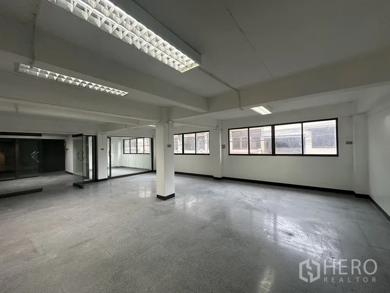 办公空间 出租在Khlong Toei, Bangkok - 明亮角落工作区，多扇窗及玻璃隔断，灰色地面