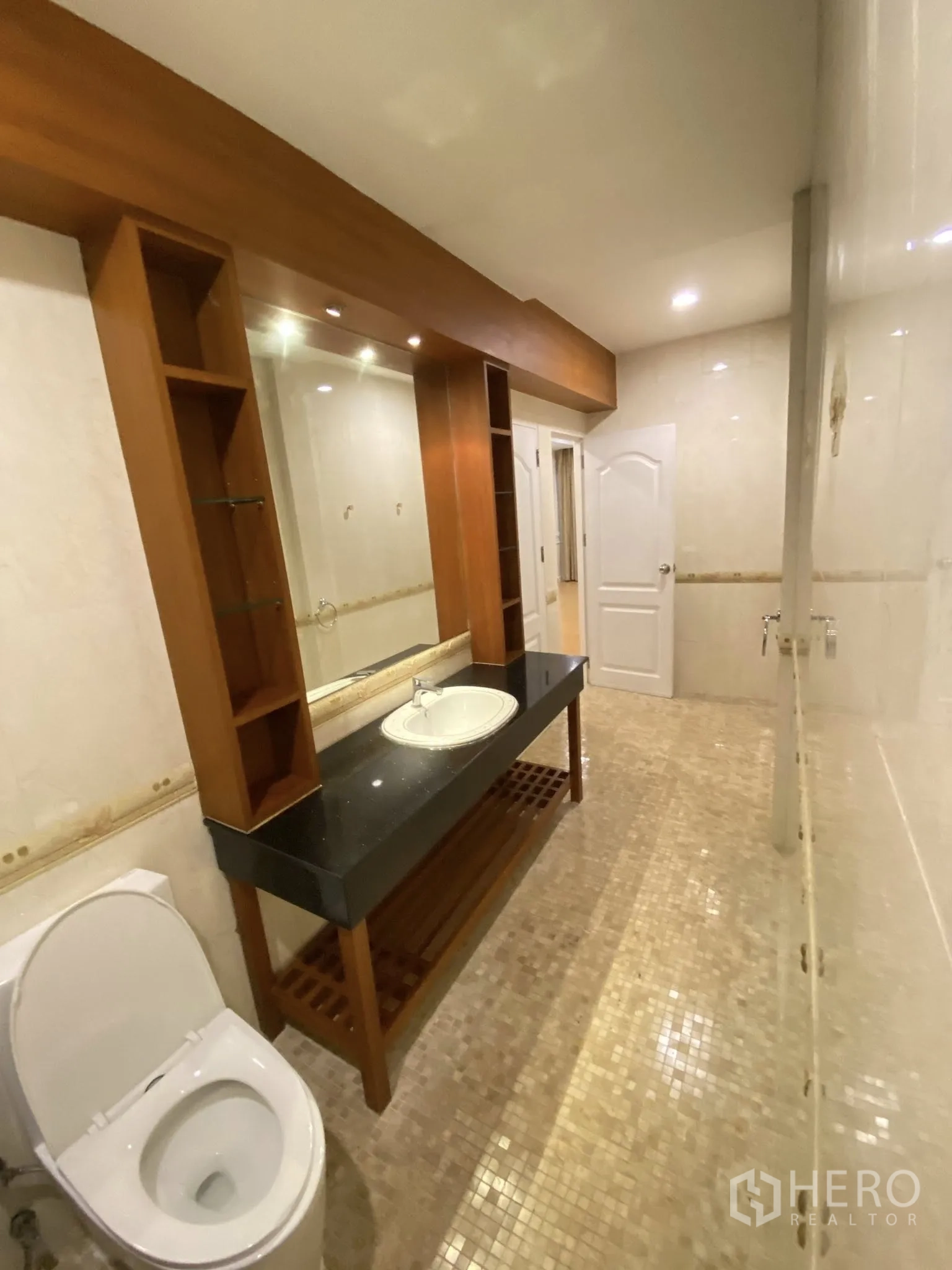 家庭办公室 for rent in Pathum Wan, Bangkok - 浴室配长条花岗岩台面、镜柜、木质置物架与坐便器。
