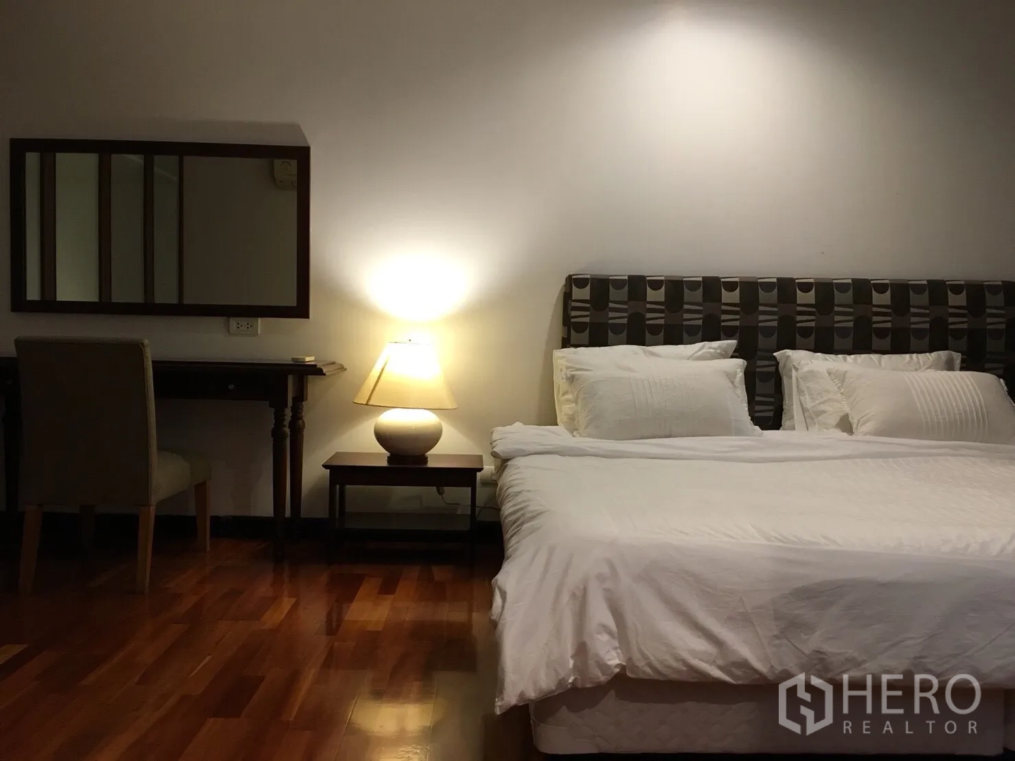 公寓 出租在Watthana, Bangkok - 主卧配大床、床头灯、梳妆台与温润木地板。