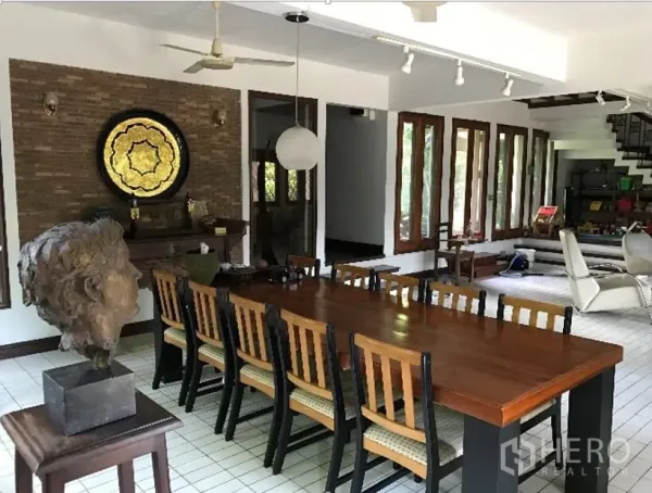 独立式住宅 出租在Khlong Toei, Bangkok - 宽敞餐厅，长木餐桌、砖砌装饰墙与轨道灯。
