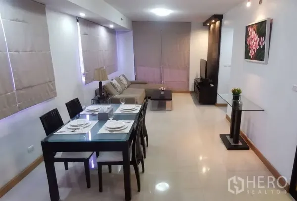 Condominium for rent in Watthana, Bangkok - Open-plan dining and living space set for four beside a lounge area.