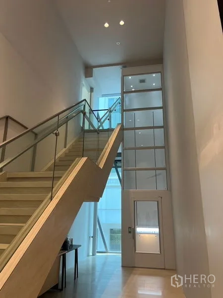 Retail Space for rent in Pathum Wan, Bangkok - Modern lobby with glass-railed staircase beside a compact lift.