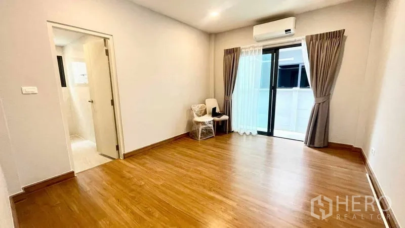 บ้าน ให้เช่าในBang Phli, Samut Prakan - ห้องนอนแขกพร้อมห้องน้ำในตัว พื้นไม้ ระเบียง และเครื่องปรับอากาศ