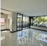 带办公室的家 出租在Wang Thonglang, Bangkok - 转角办公区，黑框落地窗与亮面地砖，采光充足。
