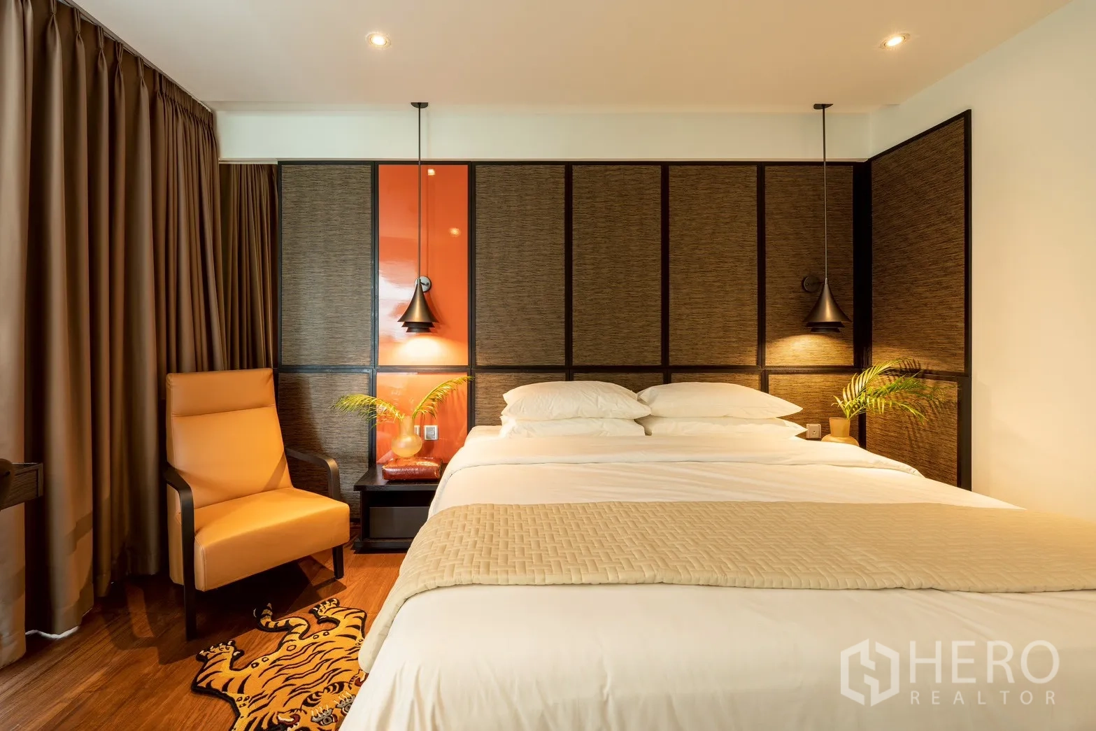 คอนโด for rent or sale in Pathum Wan, Bangkok - ห้องนอนเตียงคิงส์ ผนังตกแต่ง โคมไฟแขวน และเก้าอี้เอนกาย