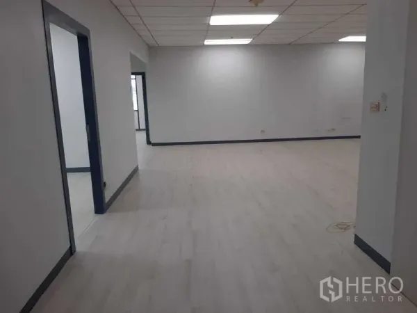 Office Space for rent in Khlong Toei, Bangkok - Spacious open-plan office area with light wood flooring and grid ceiling lights.