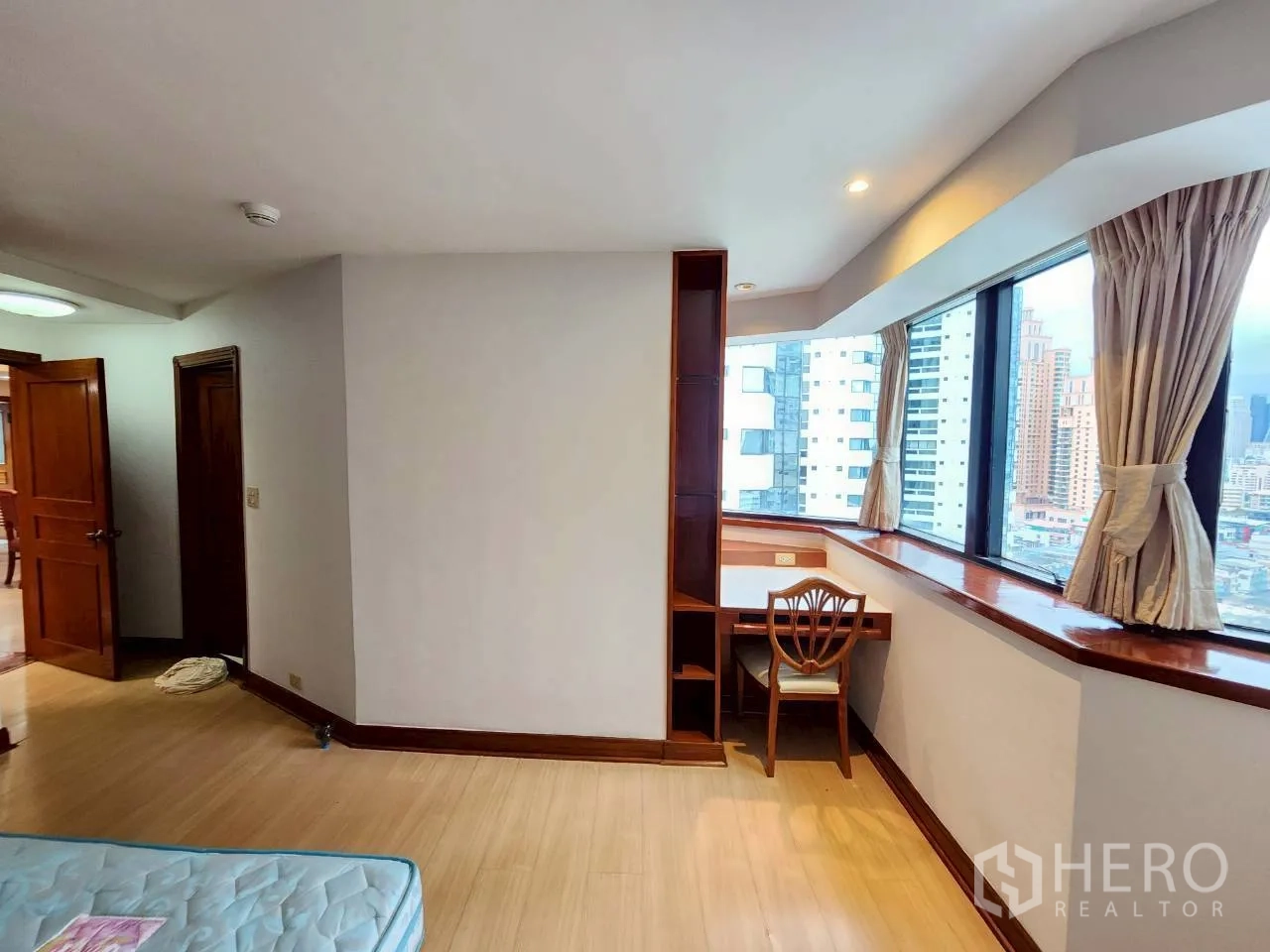 Condominium for rent in Khlong Toei, Bangkok - Bedroom corner study nook by panoramic windows with city outlook.