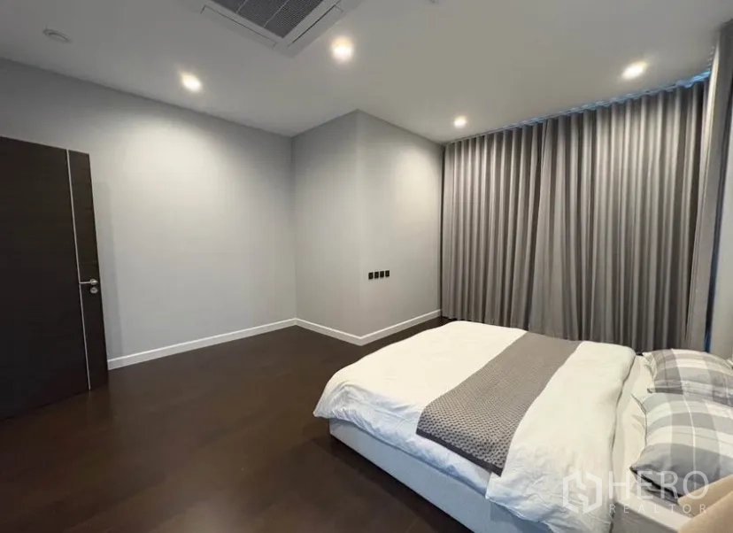บ้านเดี่ยว for rent in Suan Luang, Bangkok - ห้องนอนกว้าง พื้นไม้สีเข้ม เตียงคิงไซส์ และผ้าม่านทึบ
