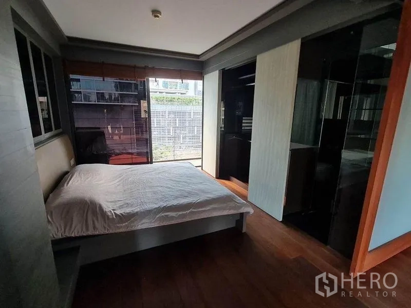 公寓 出售在Pathum Wan, Bangkok - 卧室设大窗与推拉衣柜，木地板