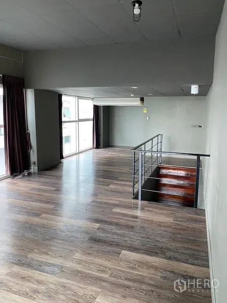 Retail Space for rent in Huai Khwang, Bangkok - Spacious upper floor with wood flooring and an open stair balustrade.
