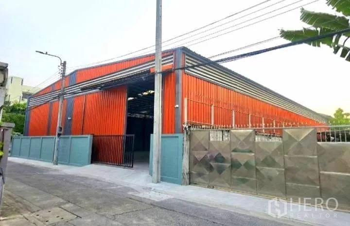 โกดัง for rent in Phaya Thai, Bangkok -  มุมมองจากถนนเห็นโกดังพร้อมประตูรั้วและกำแพงรอบพื้นที่ 