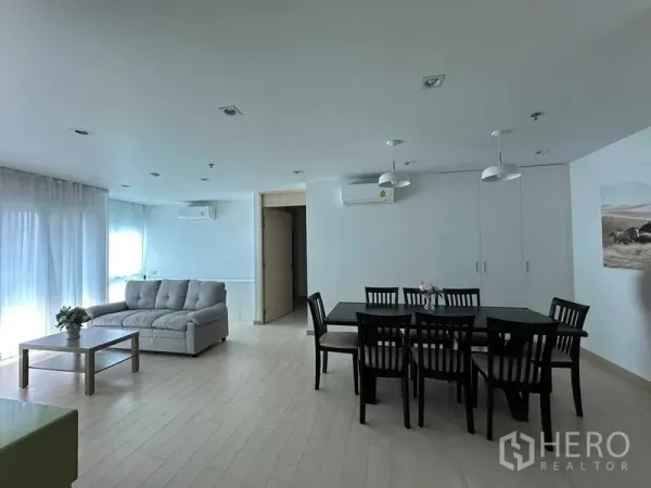 公寓 出售在Bang Rak, Bangkok - 宽敞客餐区，落地窗、纱帘与双壁挂空调。