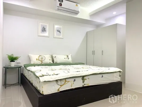 Condominium for rent or sale in Khlong Toei, Bangkok - Air-conditioned bedroom with double bed, white wardrobe and bedside table in neutral decor.