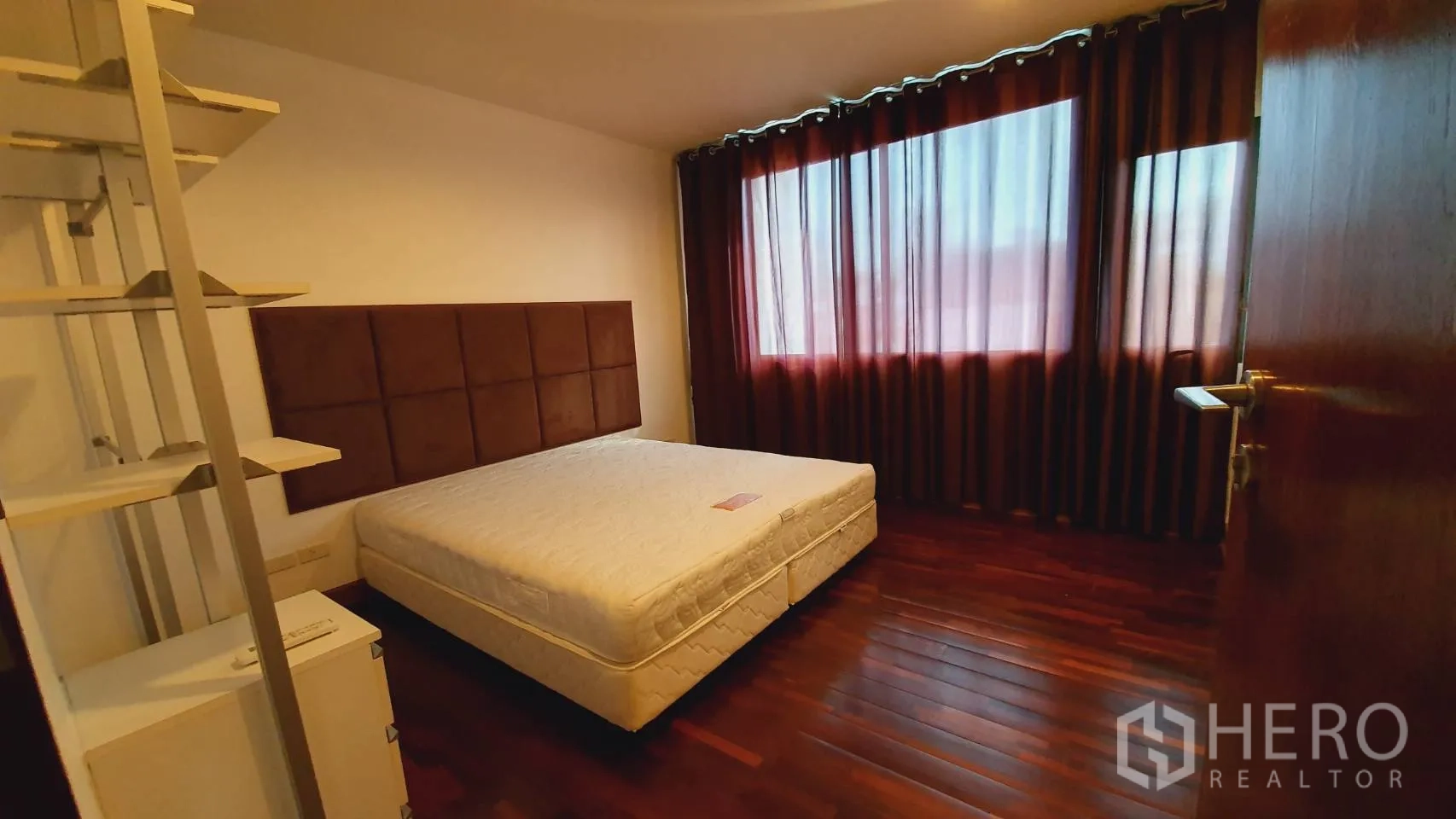公寓 出租在Khlong Toei, Bangkok - 卧室木地板，软包床头与整面窗帘。