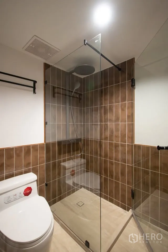 公寓 for rent in Watthana, Bangkok - 浴室设玻璃淋浴间与棕色墙砖。